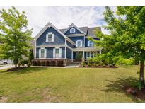 Beautiful two-story blue home with a well-manicured lawn and mature trees at 2601 Brookstone Ridge, Raleigh, NC 27613