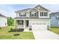 Charming two-story home with light gray siding, stone accents, and a two-car garage at 283 Hopewell Br Ct, Smithfield, NC 27577