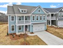 Charming two-story home with a balcony, blue siding, and a two-car garage at 3008 Dog Rose Dr # 307, Durham, NC 27703
