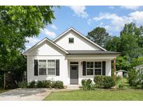 Charming home featuring a gray door, black shutters, and lush lawn with a traditional design at 303 Godwin St, Selma, NC 27576