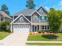 Charming two-story home boasts a well-manicured lawn, attached garage, and inviting front porch at 3413 S Beaver Ln, Raleigh, NC 27604