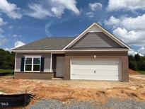 Charming single-story home featuring brick accents, gray siding, and a white garage door at 48 Spirit Springs Rd, Smithfield, NC 27577