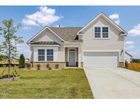 Charming two-story home features a well-maintained lawn and an attached two-car garage at 504 Winding Creek Dr Dr, Lillington, NC 27546