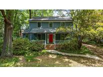 Charming two-story home with a welcoming porch and vibrant red front door surrounded by lush landscaping at 522 Lochness Ln, Cary, NC 27511