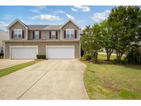 Charming townhome with a two-car garage and well-maintained lawn at 524 Woodson Dr, Clayton, NC 27527