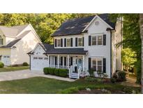 Charming two-story home with black shutters, a covered porch and a manicured front lawn at 535 W Holding Ave, Wake Forest, NC 27587