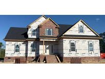 New home construction with brick facade, covered porch, black roof, and visible Home Guard wrap at 7491 Sweetwater Dr, Nashville, NC 27856