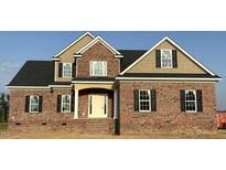 New construction home boasts a brick exterior, complemented by tan siding and black shutters at 7491 Sweetwater Dr, Nashville, NC 27856