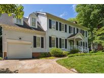 Charming two-story home with white siding, black shutters, attached garage, and well-manicured lawn at 7804 Tylerton Dr, Raleigh, NC 27613