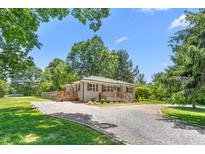 Charming home featuring a gravel driveway, two wooden decks, and light gray brick at 827 Loop Rd Rd, Burlington, NC 27217