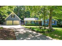 Charming home featuring a large front yard, blue siding, a detached garage, and a long driveway at 8513 Applecross Cir, Apex, NC 27539