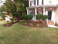 Charming home featuring a well-manicured front yard, lush lawn, and inviting front porch at 9009 Miranda Dr, Raleigh, NC 27617