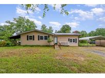 Charming single-story home with a covered parking area and a well-maintained front yard at 1012 Roxboro St, Haw River, NC 27258