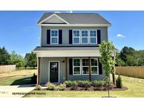 Charming two-story home with blue siding, dark shutters, covered porch, and beautifully landscaped yard at 107 Legolas Ct, Middlesex, NC 27557
