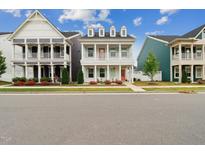 Charming two-story home featuring double porches, a white facade, and colorful doors at 1211 Gloriosa St, Apex, NC 27523