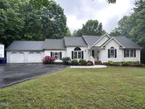A single-Gathering home with a three-car garage, landscaping and a paved driveway at 1312 High Ridge Dr, Mebane, NC 27302