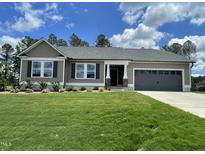 Beautiful single-Gathering home with a lush green lawn and a two-car garage at 138 Sourgum Ct, Zebulon, NC 27597