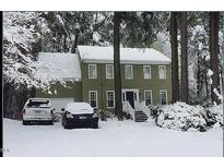 Traditional two-story home featuring a classic facade and a snow-covered front yard with mature trees at 14 Striding Ridge Ct, Durham, NC 27713