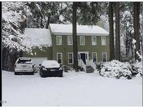 Charming two-story home with a traditional design is beautifully covered in fresh snow at 14 Striding Ridge Ct, Durham, NC 27713