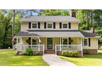 Charming two-story home featuring a welcoming front porch, black shutters, and a well-maintained lawn at 148 Shadowbrook Dr, Henderson, NC 27537