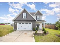 Two-story home with a two-car garage, gray and white siding, well-maintained lawn, and a concrete driveway at 152 Briar Den Ct, Benson, NC 27504