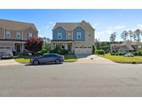 Charming two-story home with a two-car garage, blue accents, and a well-maintained front yard at 1600 Tinos Overlook Way, Apex, NC 27502