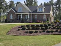 Charming brick home featuring manicured landscaping, complemented by mature trees and a classic architectural design at 1655 Kingfisher Ct, Nashville, NC 27856