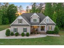 Charming two-story home featuring professional landscaping and a welcoming front porch with an American flag at 175 Lockamy Ln, Youngsville, NC 27596