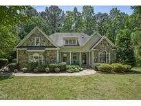 Charming stone-accented home with manicured lawn and lush landscaping creating great curb appeal at 2709 Penfold Ln, Wake Forest, NC 27587