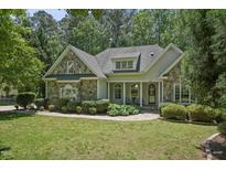 Charming stone and siding home with a well-manicured lawn and inviting front porch at 2709 Penfold Ln, Wake Forest, NC 27587