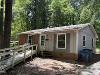 Quaint single-story home with a mix of brick and siding, complemented by lush greenery at 317 Gary St, Durham, NC 27703