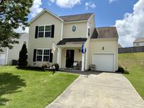 Charming two-story home with light yellow siding, black shutters, green lawn, and an attached one-car garage at 3848 Griffis Glen Dr, Raleigh, NC 27610