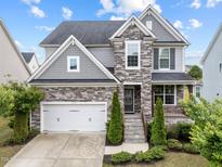 Charming two-story home with stone accents, attached garage, and well-manicured landscaping at 5104 Windmere Chase Dr, Raleigh, NC 27616