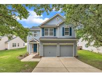 Charming two-story home boasts a two-car garage, inviting curb appeal, and mature trees at 522 Crossview Ln, Durham, NC 27703