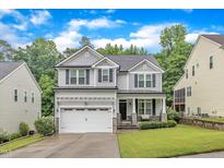 Beautiful two-story home with gray siding, black shutters, and a well-manicured lawn at 5412 Robbins Dr, Raleigh, NC 27610