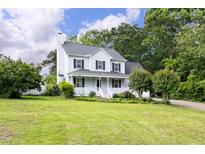 Inviting two-story home with a well-manicured lawn and charming front porch, perfect for relaxing outdoors at 59 Troy Dr, Fuquay Varina, NC 27526