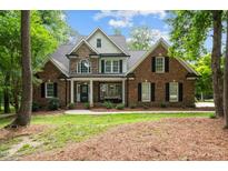 Stunning brick home with stone accents, dormer window, a welcoming porch and beautifully landscaped front yard at 5916 Two Pines Trl, Wake Forest, NC 27587