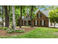 Charming brick home with black shutters, complemented by a landscaped yard and mature trees at 5916 Two Pines Trl, Wake Forest, NC 27587