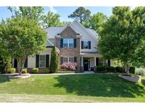 Charming two-story home with stone accents, a landscaped yard, and mature trees at 713 Liberty Cliff Dr, Cary, NC 27519