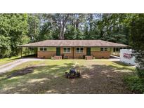 Charming duplex with brick exterior, green trim, and spacious yard in a wooded setting at 725-727 Locust Ln, Raleigh, NC 27603