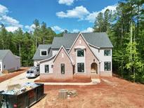 Newly built two-story home boasts gray siding, brick accents, black window trim and an arched entryway at 7932 Wexford Waters Ln, Wake Forest, NC 27587