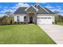 Charming two-story home with stone accents, attached two-car garage, and a well-maintained lawn at 87 Addison Pond Ct # 12, Zebulon, NC 27597