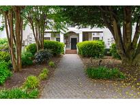 Inviting exterior entrance with a brick walkway and lush landscaping at 1000 Brighthurst Dr # 104, Raleigh, NC 27605