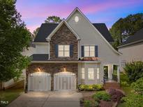Charming home featuring a stone and siding exterior with an attached two-car garage and manicured landscaping at 12217 Beestone Ln, Raleigh, NC 27614