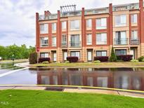 Modern townhome exterior with brick facade, balconies, and well-maintained landscaping at 1230 Capability Dr # 106, Raleigh, NC 27606