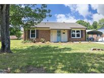 Charming brick home with a well-maintained lawn and a light blue front door, perfect for a cozy feel at 1422 Duggins Dr, Burlington, NC 27217