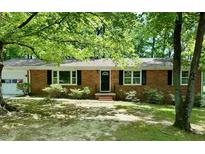 Charming brick ranch home with well-maintained landscaping, black shutters and an arched front door at 1713 S Garnett St, Henderson, NC 27536