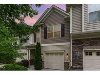 Charming townhouse features a tan exterior with brown accents, a one-car garage and manicured landscaping at 172 Token House Rd, Durham, NC 27703