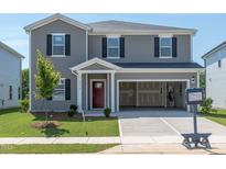 Charming two-story home with gray siding, black shutters, a red door and a two car garage at 2234 Cherry Creek Rd, Haw River, NC 27258