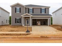 Two-story home featuring gray siding, black shutters, a front porch, and an attached two-car garage at 2234 Cherry Creek Rd, Haw River, NC 27258
